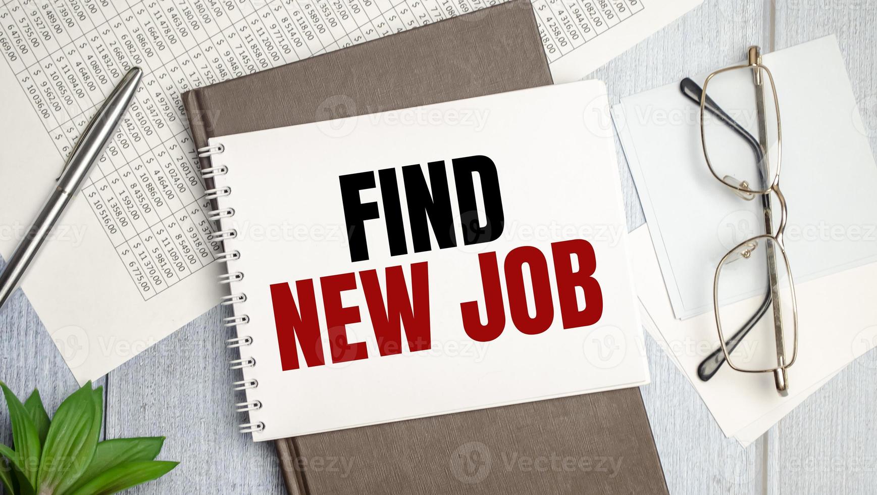 Find New Job word on sheet of paper on wooden background photo