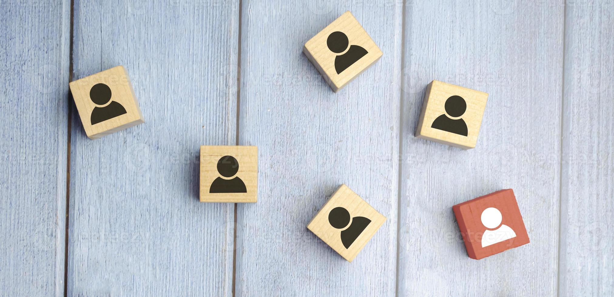 construyendo un equipo fuerte, bloques de madera con ícono de personas en el fondo azul, foto