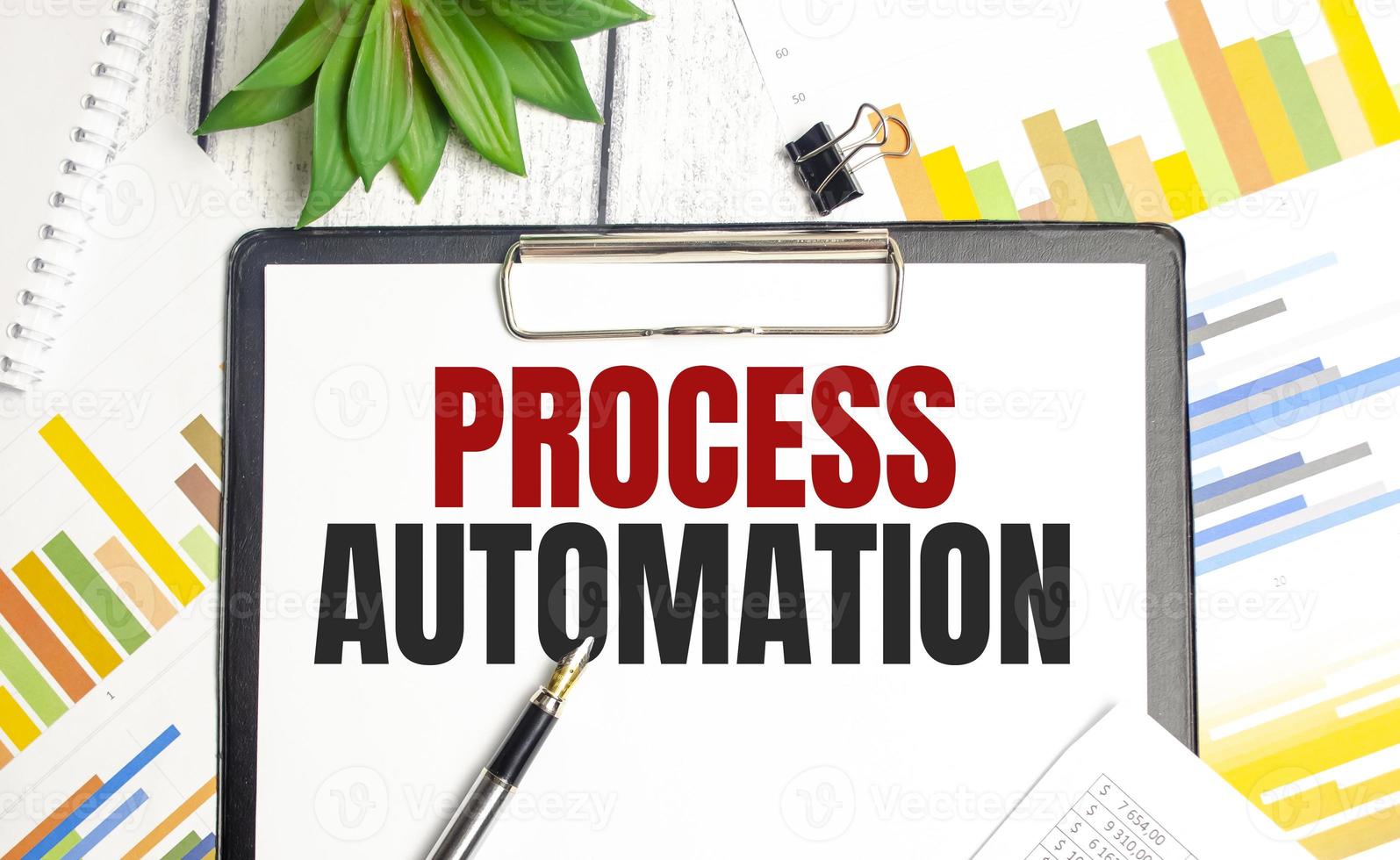 PROCESS AUTOMATION text on file folder and charts on wooden background photo