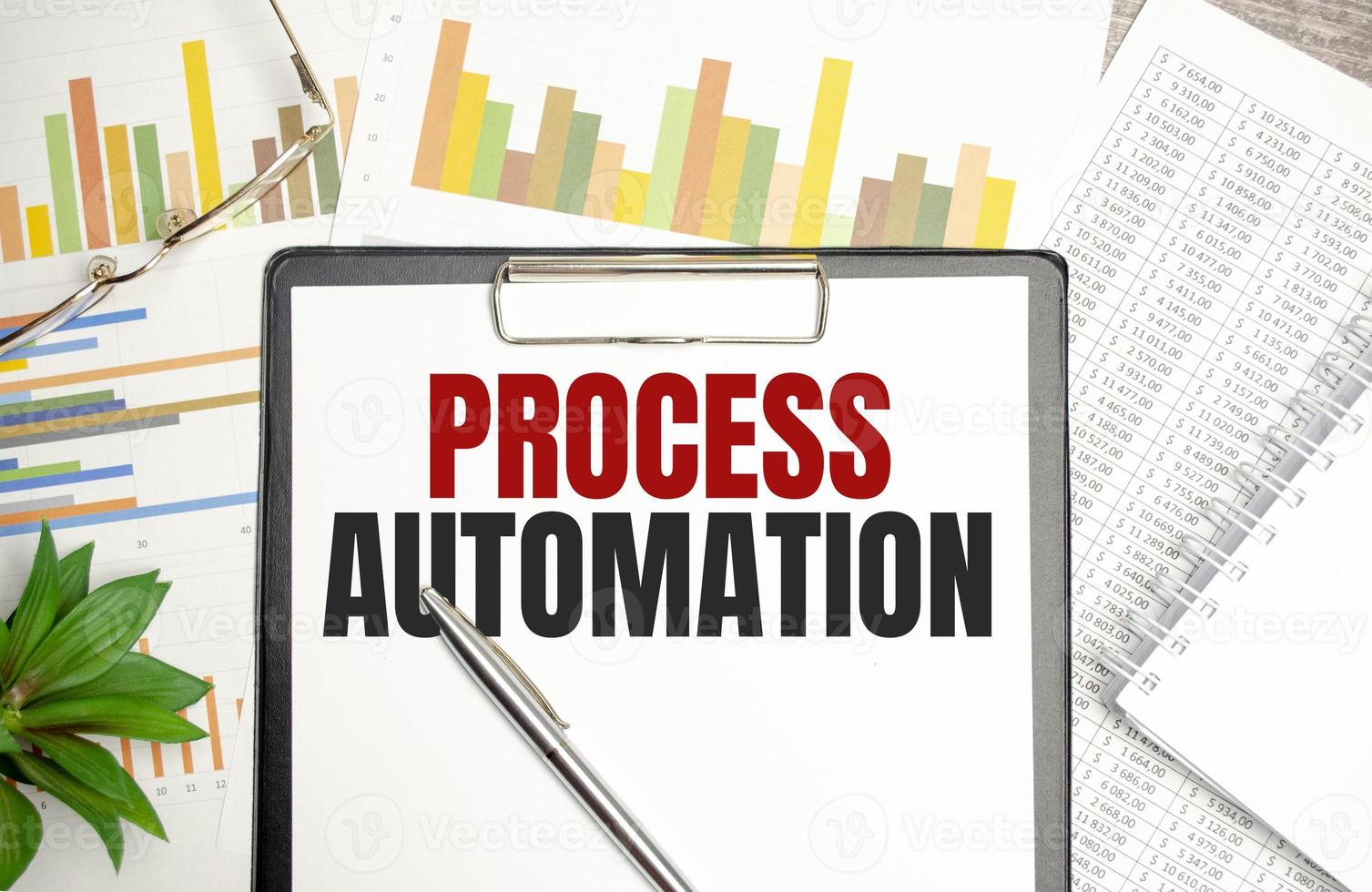 PROCESS AUTOMATION text on file folder and charts on wooden background photo