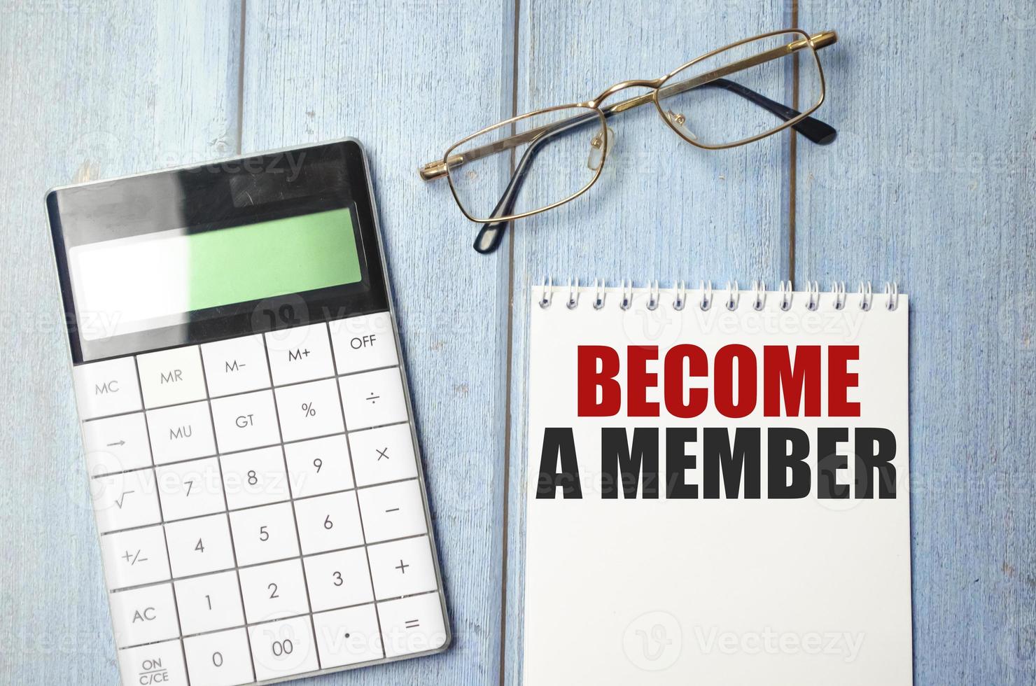 Become a member text on notepad and glasses, calculator on wooden background photo