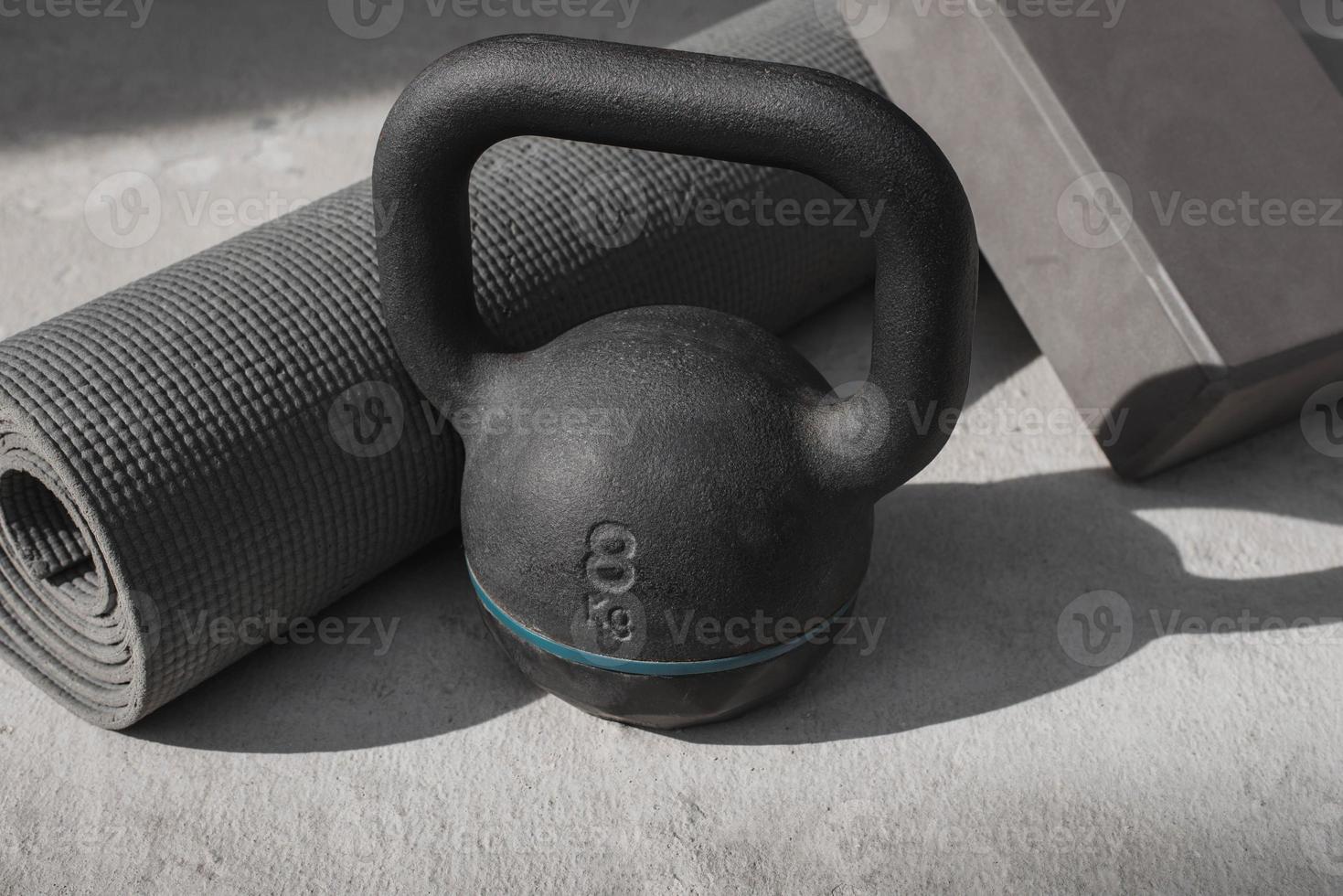 Kettlebell and yoga mat on the floor at home. gym equipment. photo