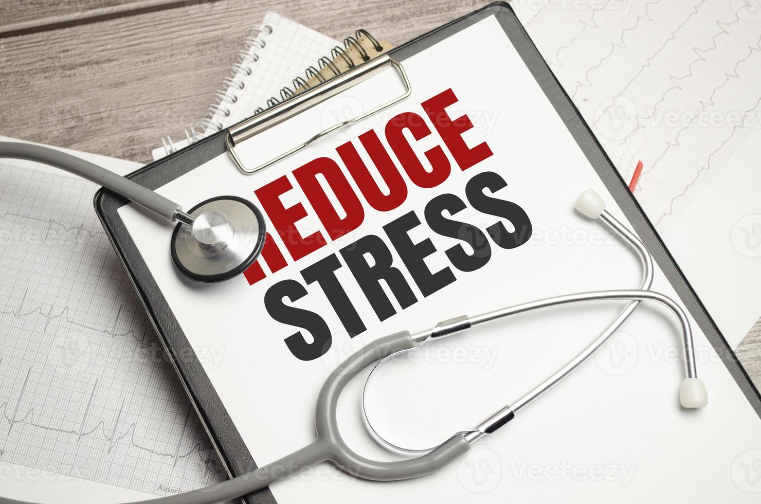 Text Reduce stress on a white background with stethoscope photo