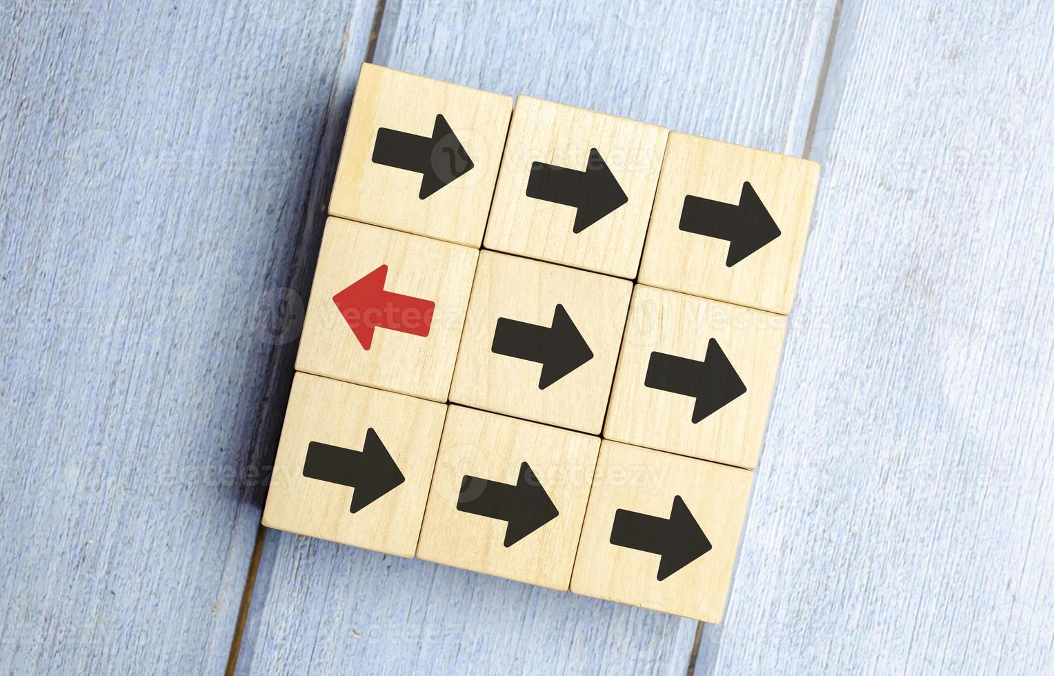 Leadership concept, Red wooden block with arrow icon on blue background. photo