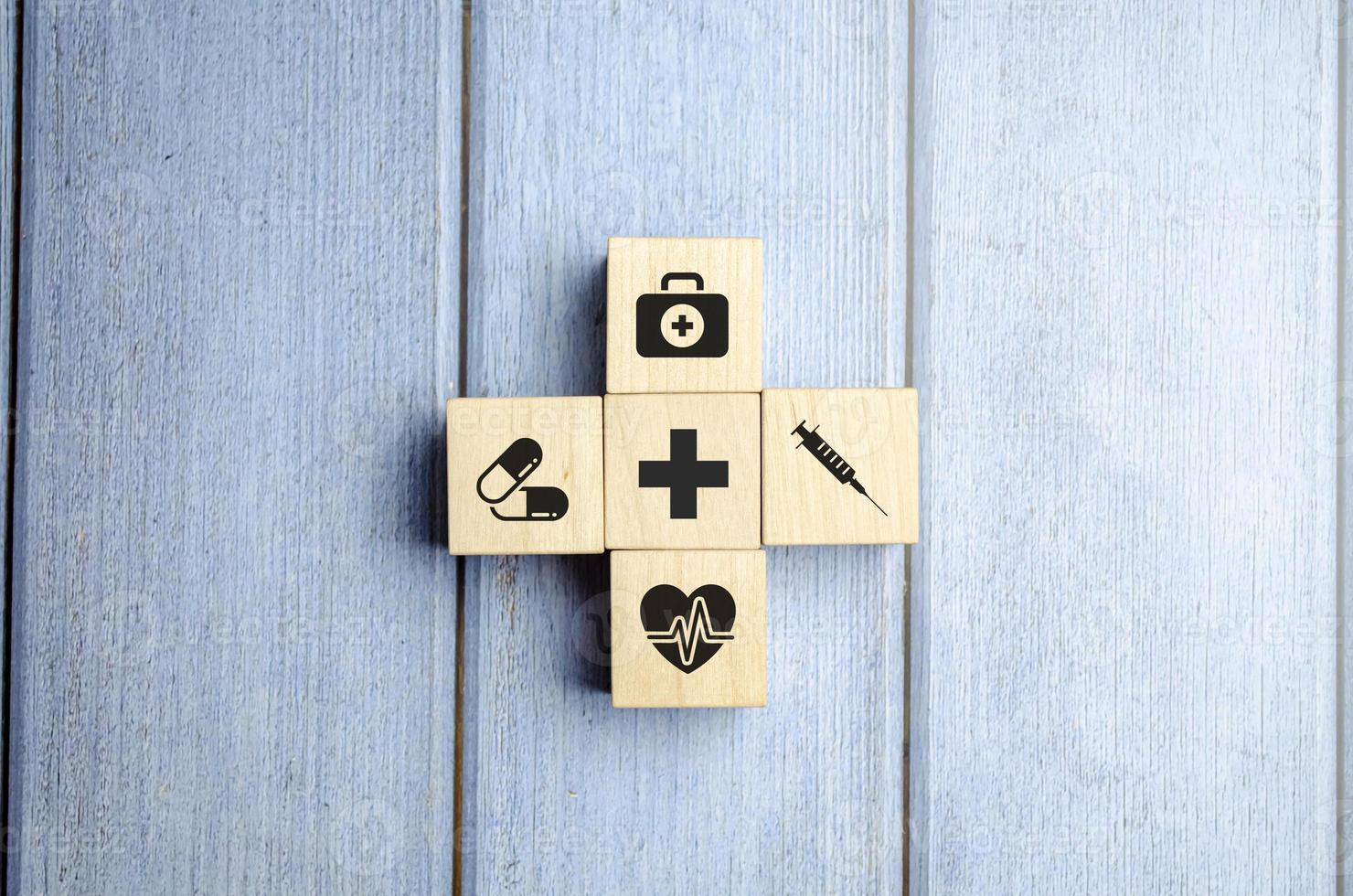 concepto de seguro médico, bloques de madera con icono médico sanitario, fondo azul foto