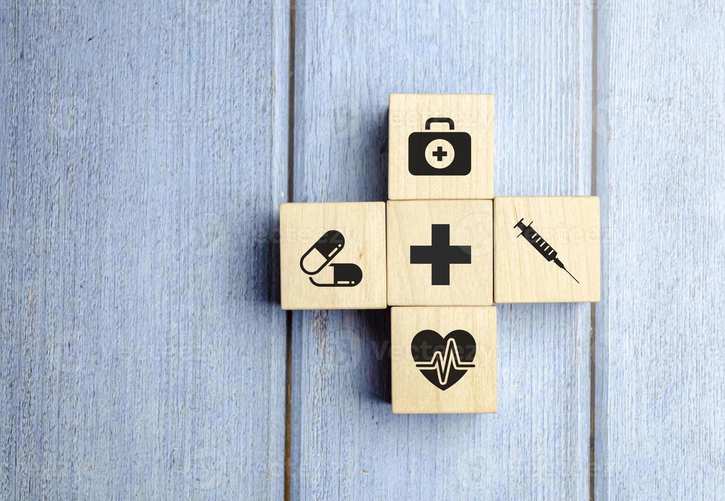 concepto de seguro médico, bloques de madera con icono médico sanitario, fondo azul foto