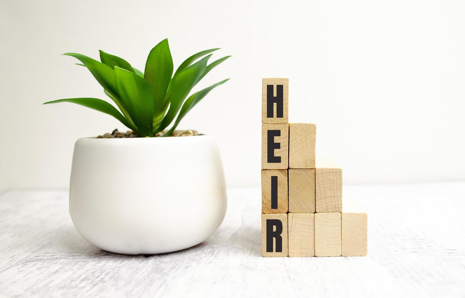 Word HEIR made from wooden blocks on white background photo