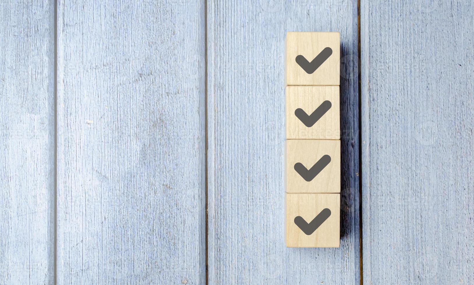 Checklist concept, Check mark on wooden blocks, blue background with copy space photo