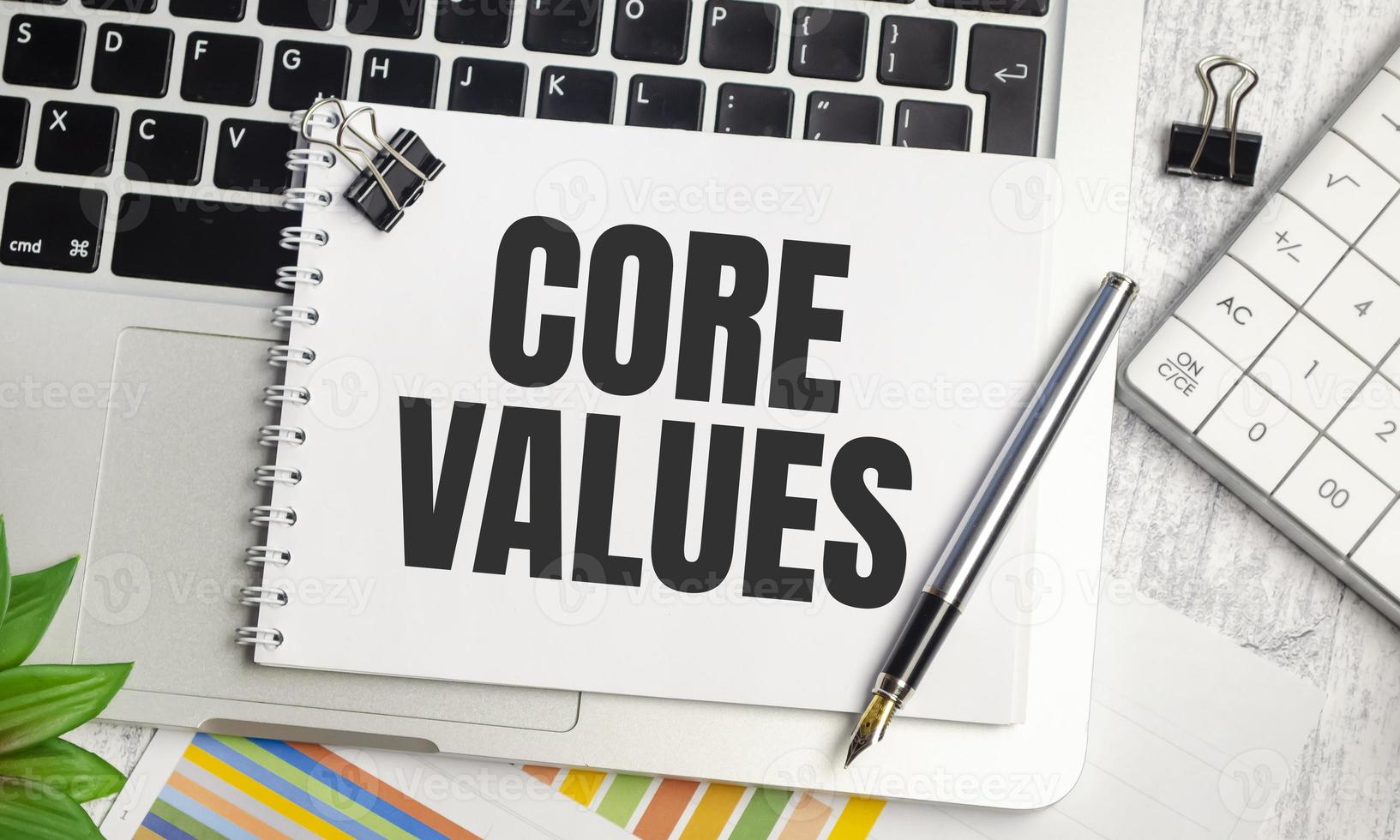 core values symbol. White note with words Our core values on beautiful wooden table photo