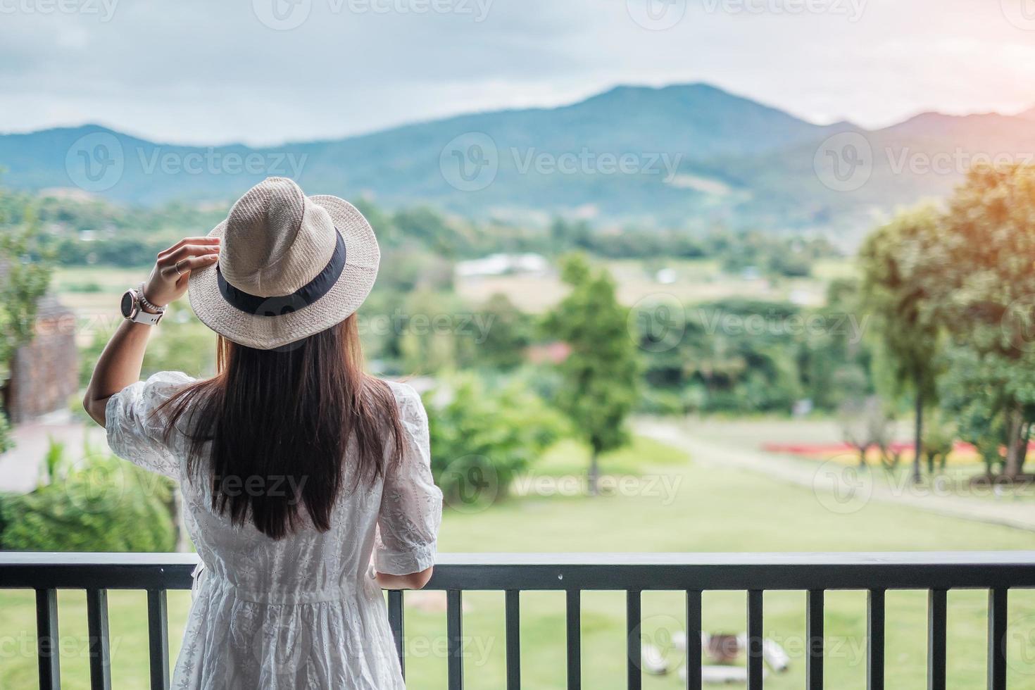 Happy woman in white dress and hat looking beautiful Nature view. Relaxing, travel, nature, vacation and holiday concept photo