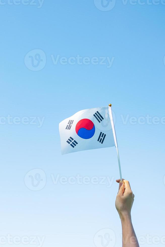 hand holding Korea flag on nature background. National Foundation, Gaecheonjeol, public Nation holiday, National Liberation Day of Korea and happy celebration concepts photo