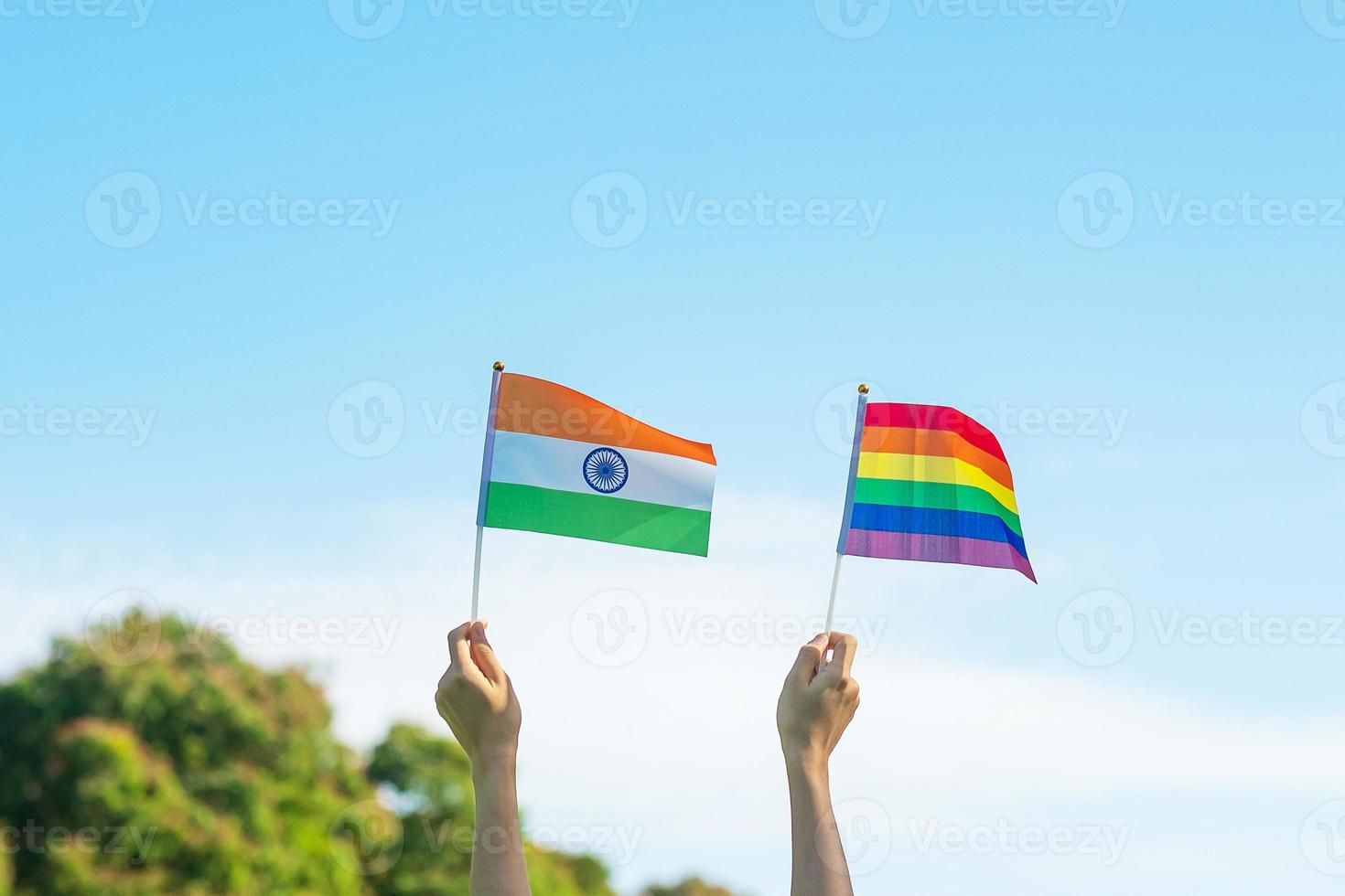 hands showing LGBTQ Rainbow and India flag on nature background. Support Lesbian, Gay, Bisexual, Transgender and Queer community and Pride month concept photo