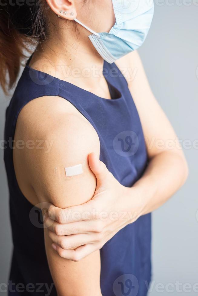 woman showing her arm with bandage after receiving covid 19 vaccine. Vaccination, herd immunity, side effect, vaccine efficiency and Coronavirus pandemic photo