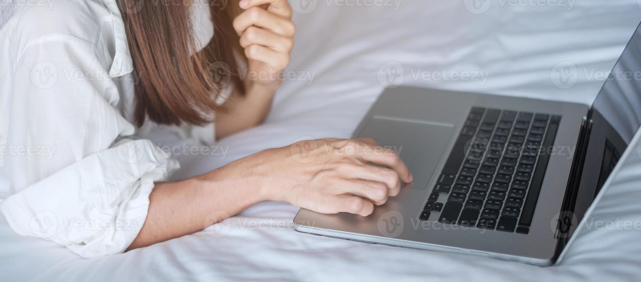 Happy woman using laptop for work, female meeting  online by computer notebook on bed. technology, network, work from home, lifestyle and digital communication concept photo