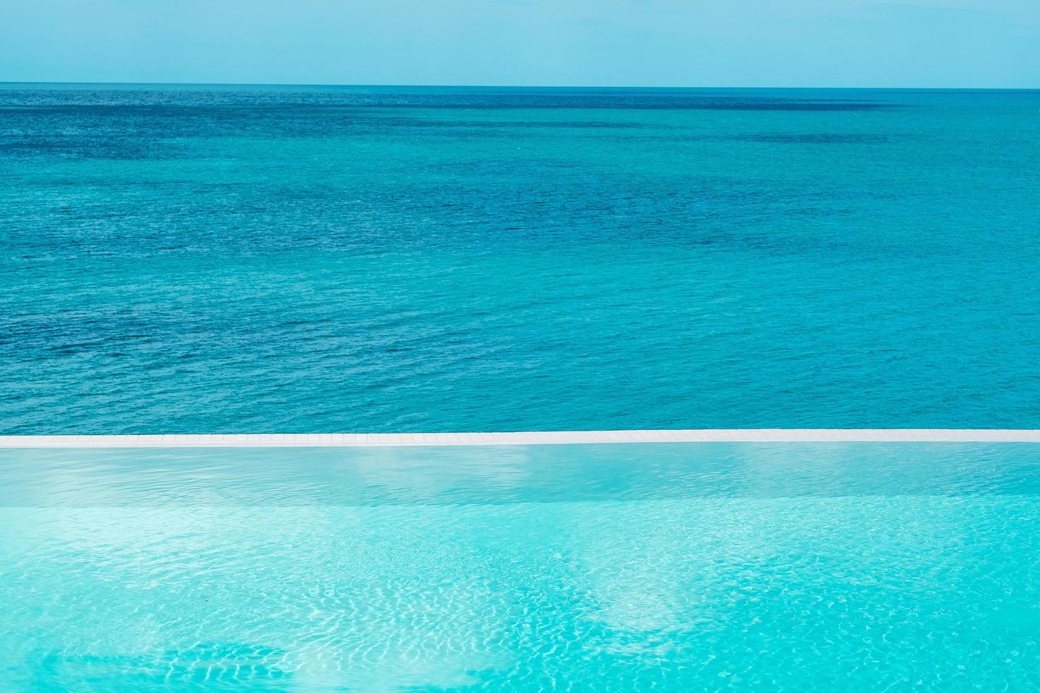 infinity pool at luxury hotel against ocean front, tropical resort. Relaxing, summer,  travel, holiday, vacation and weekend concept photo