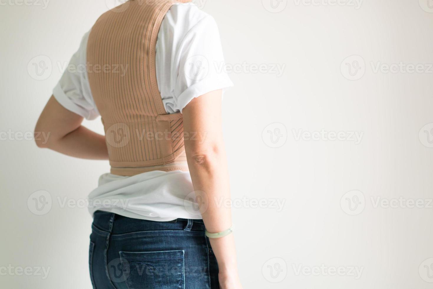 A woman wearing back support belt in healthcare concept. photo