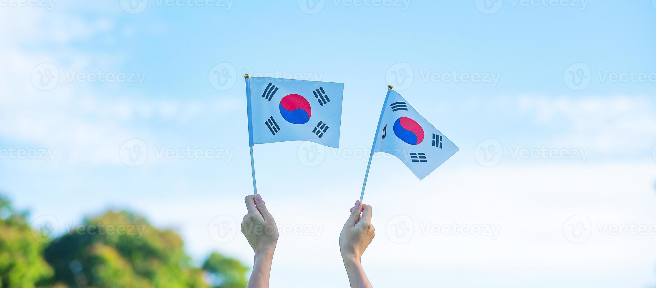 hand holding Korea flag on nature background. National Foundation, Gaecheonjeol, public Nation holiday, National Liberation Day of Korea and happy celebration concepts photo