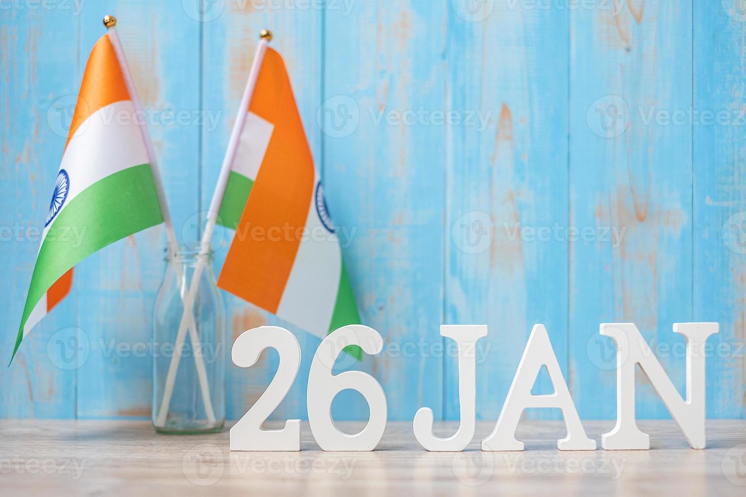texto de madera del 26 de enero con banderas indias en miniatura. día de la república india y conceptos de celebración feliz foto
