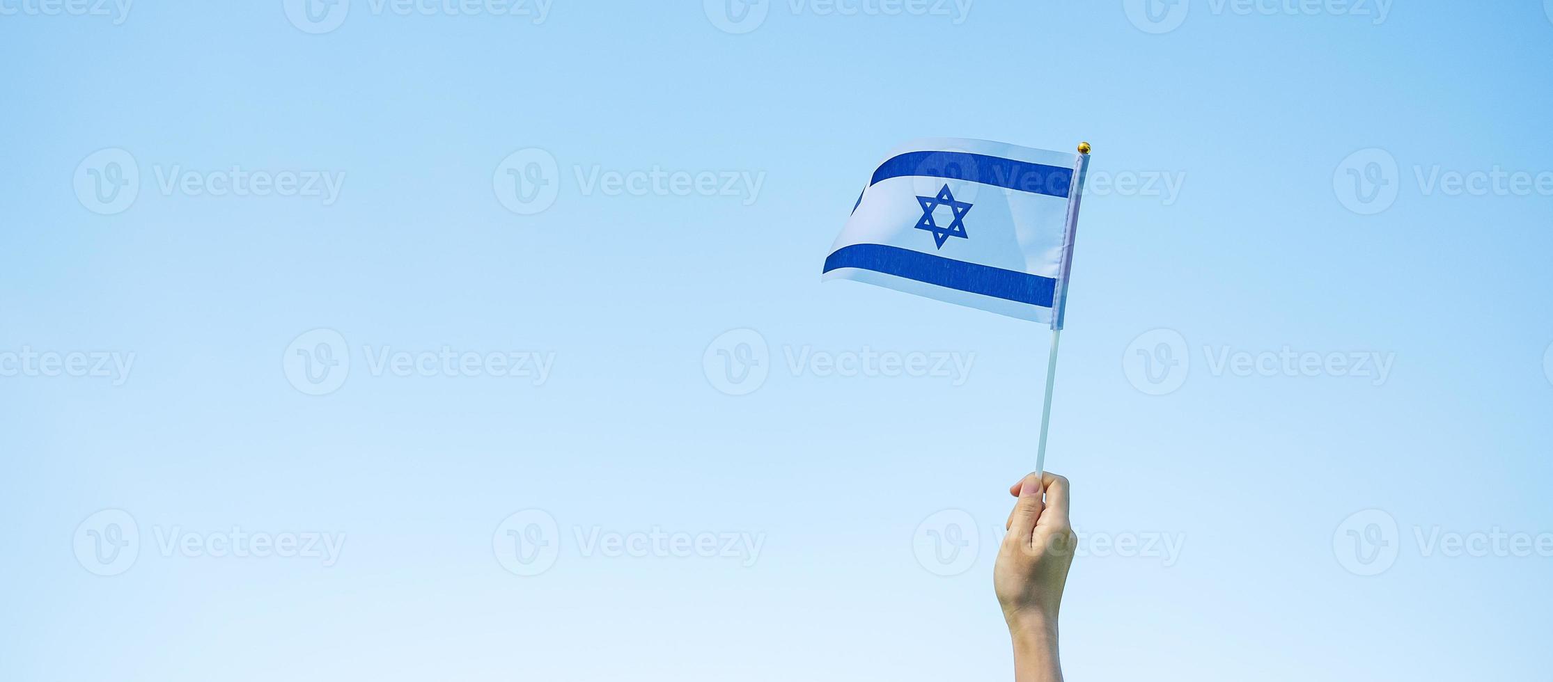 hand holding Israel flag on nature background. Israel Independence day and happy celebration concepts photo