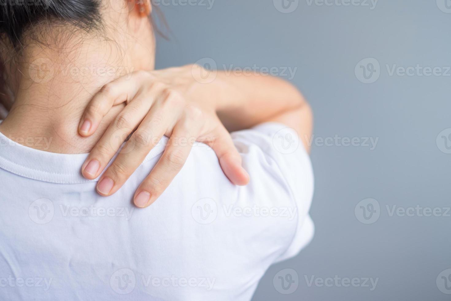 woman with her shoulder sprain, muscle painful during overwork. Girl having body problem after wake up. Shoulder ache, Scapular pain, office syndrome and ergonomic concept photo