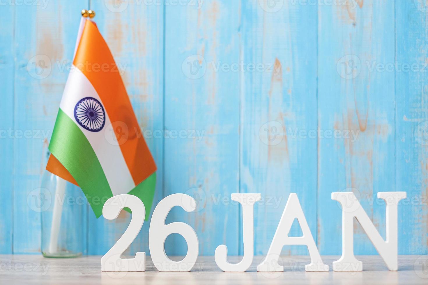 texto de madera del 26 de enero con banderas indias en miniatura. día de la república india y conceptos de celebración feliz foto