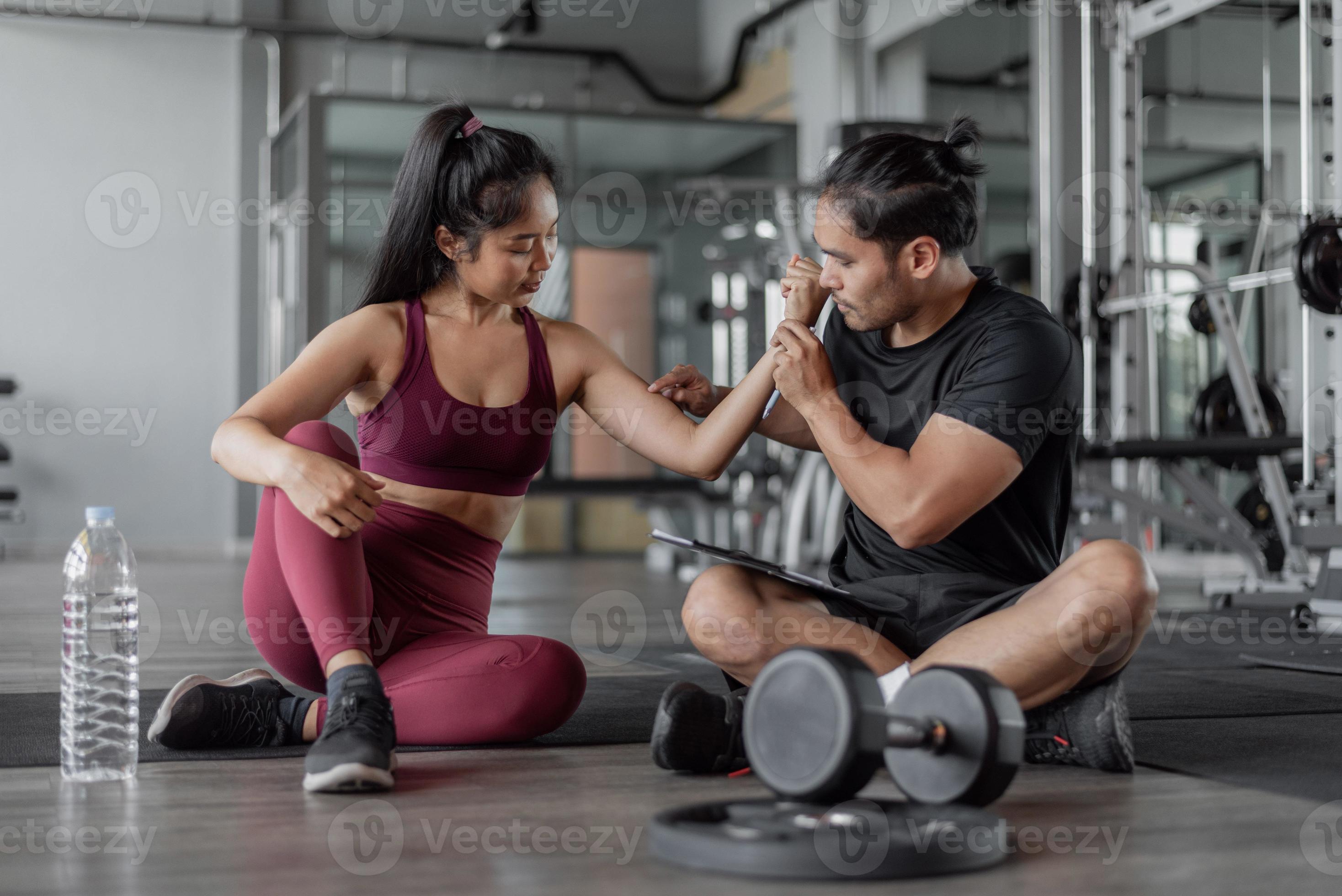 Asian woman exercise with personal trainer in gym. healthy woman talking  with personal trainer in fitness. 9174465 Stock Photo at Vecteezy
