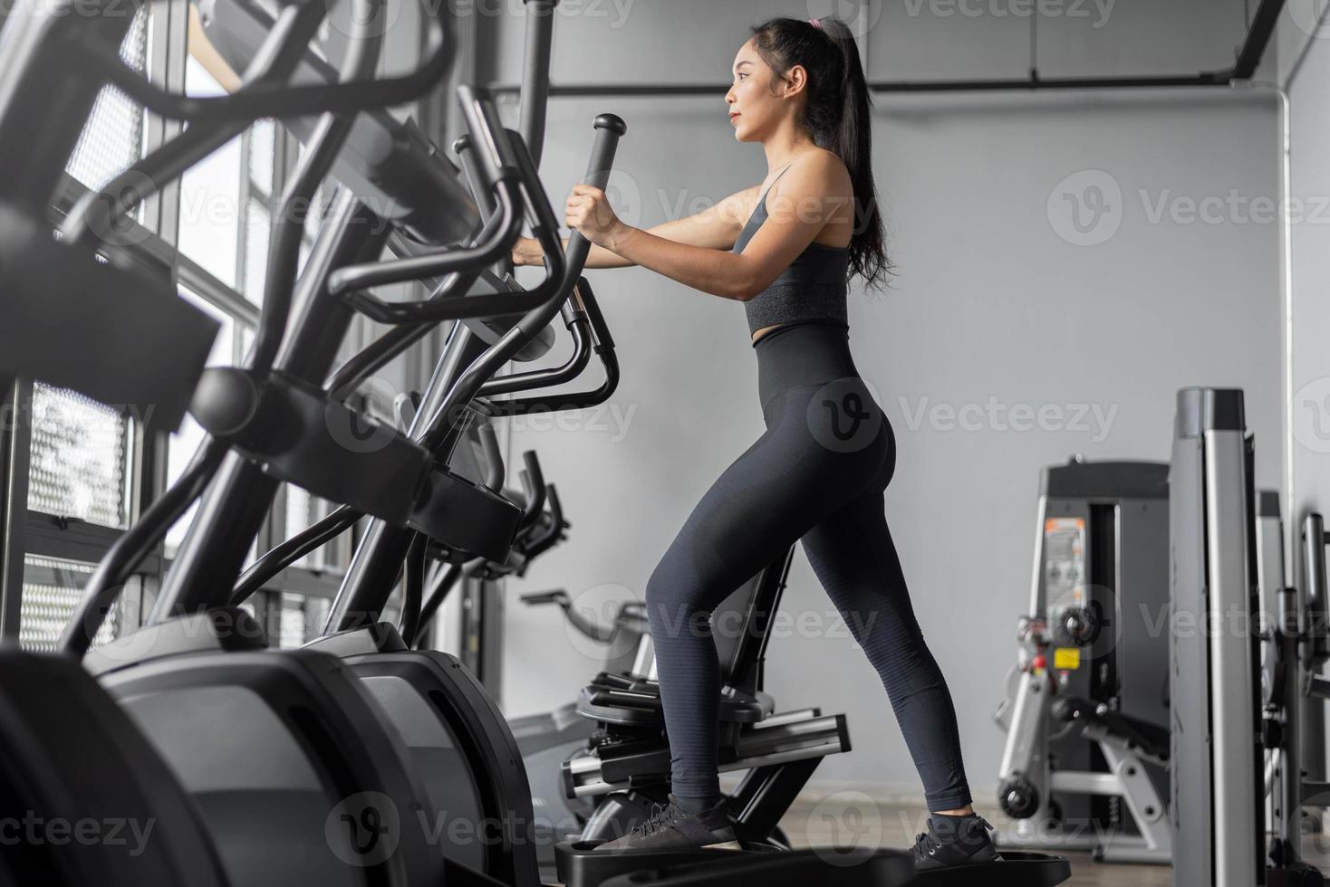 Asian woman exercises in fitness. Young healthy woman in sportswear is cardio exercises in gym. photo