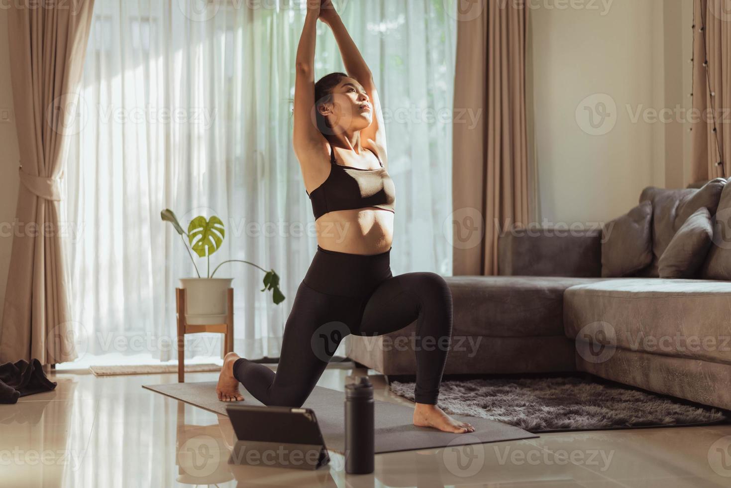 mujer joven practicando yoga en casa. forma en ropa deportiva haciendo yoga en línea en casa en la sala de estar. 9178535 Foto de stock en