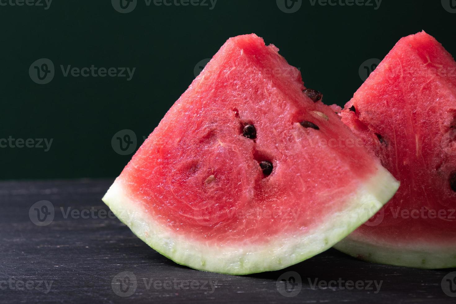 Pieces of refreshing watermelon on a dark wood background. Close-up photo. Fruit texture. High quality photo
