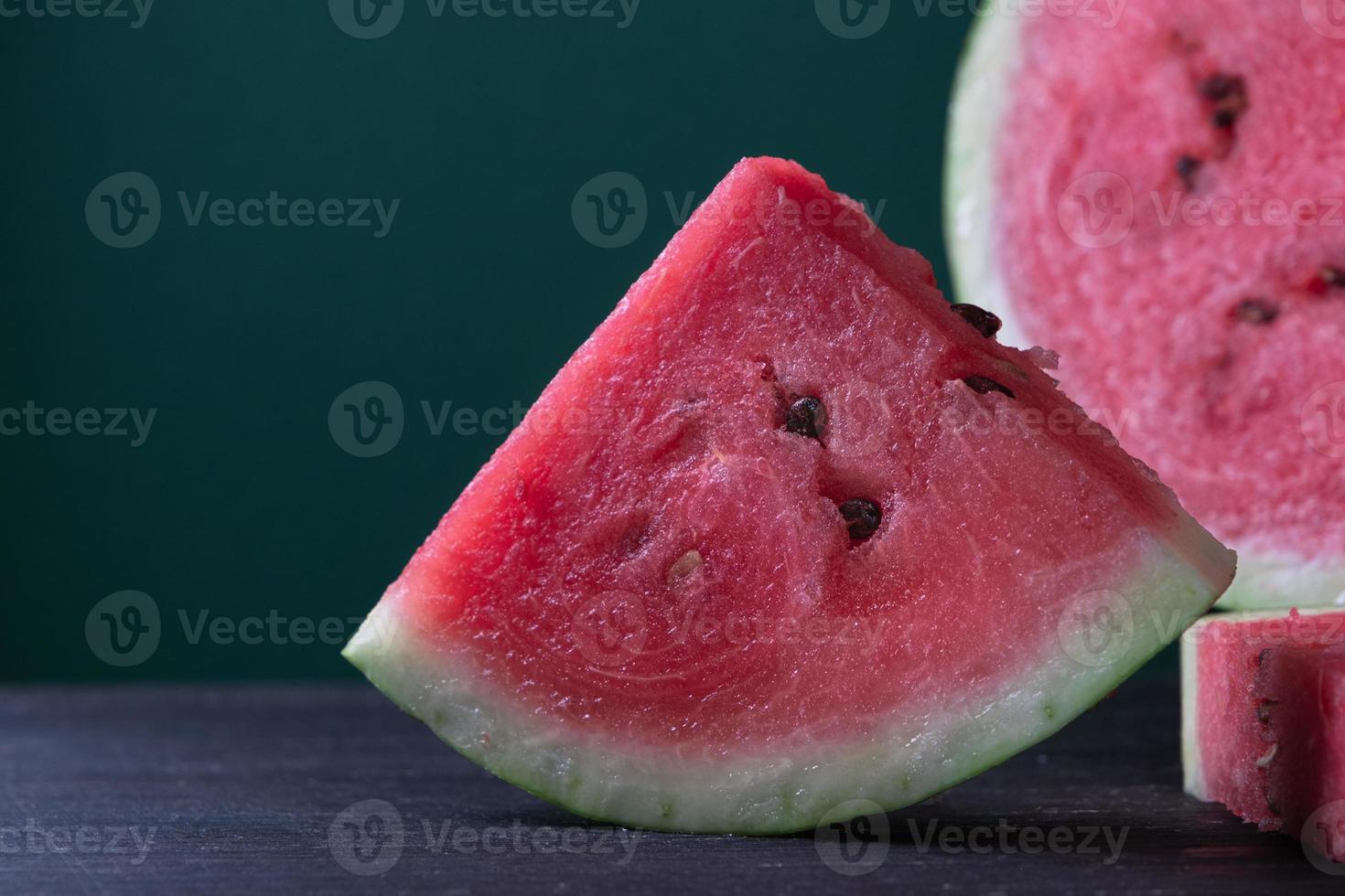 Pieces of refreshing watermelon on a dark wood background. Close-up photo. Fruit texture. High quality photo