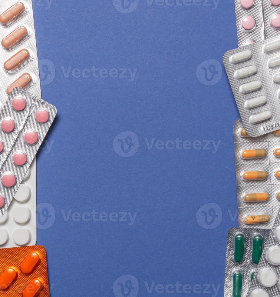 Different medicines, tablets, pills in blister pack, medications drugs on blue background. Close-up photo, copy space, top view. High quality photo