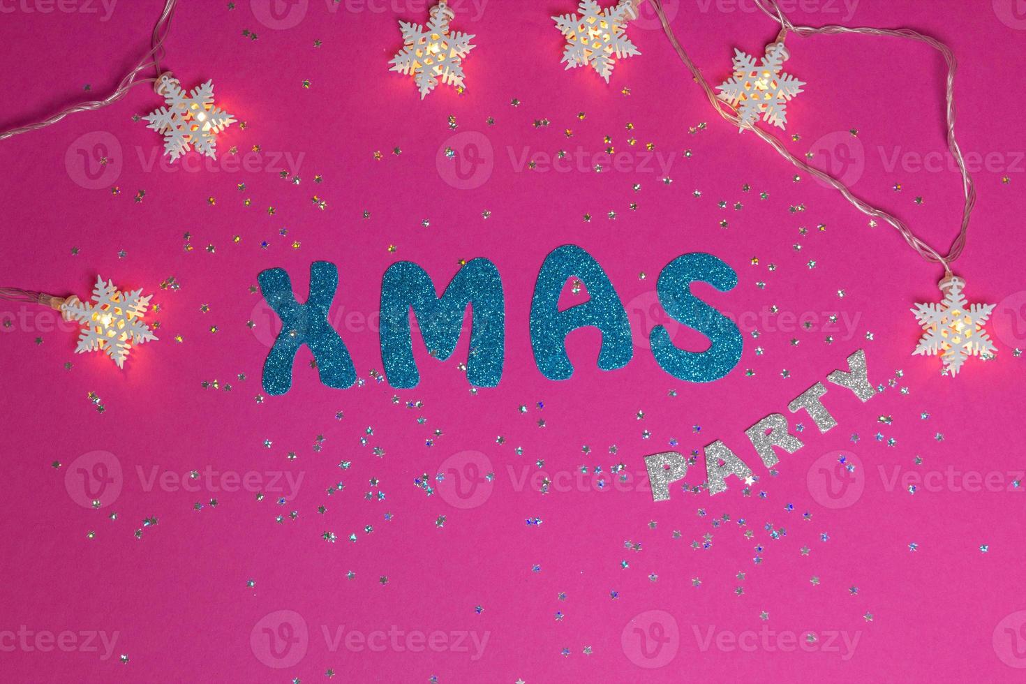 Words Xmas Party on pink background with glittered little stars and stars garland. Christmas inscription with space for text writing, greeting. Concept for Christmas card. Top view. High quality photo