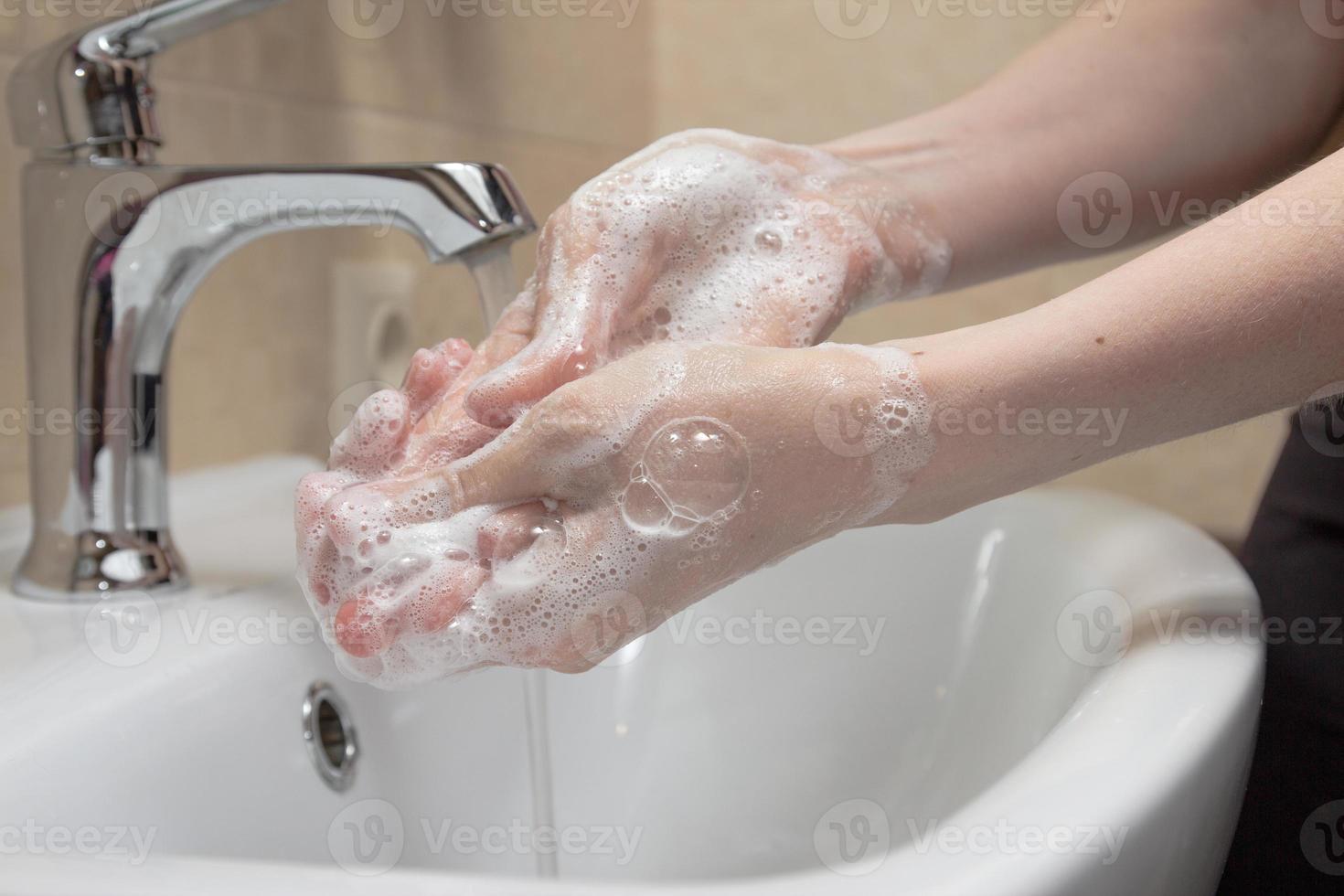 Hygiene. Cleaning Hands. Washing hands with soap. Woman's hand with foam. Protect yourself from coronavirus COVID-19 pandemia photo