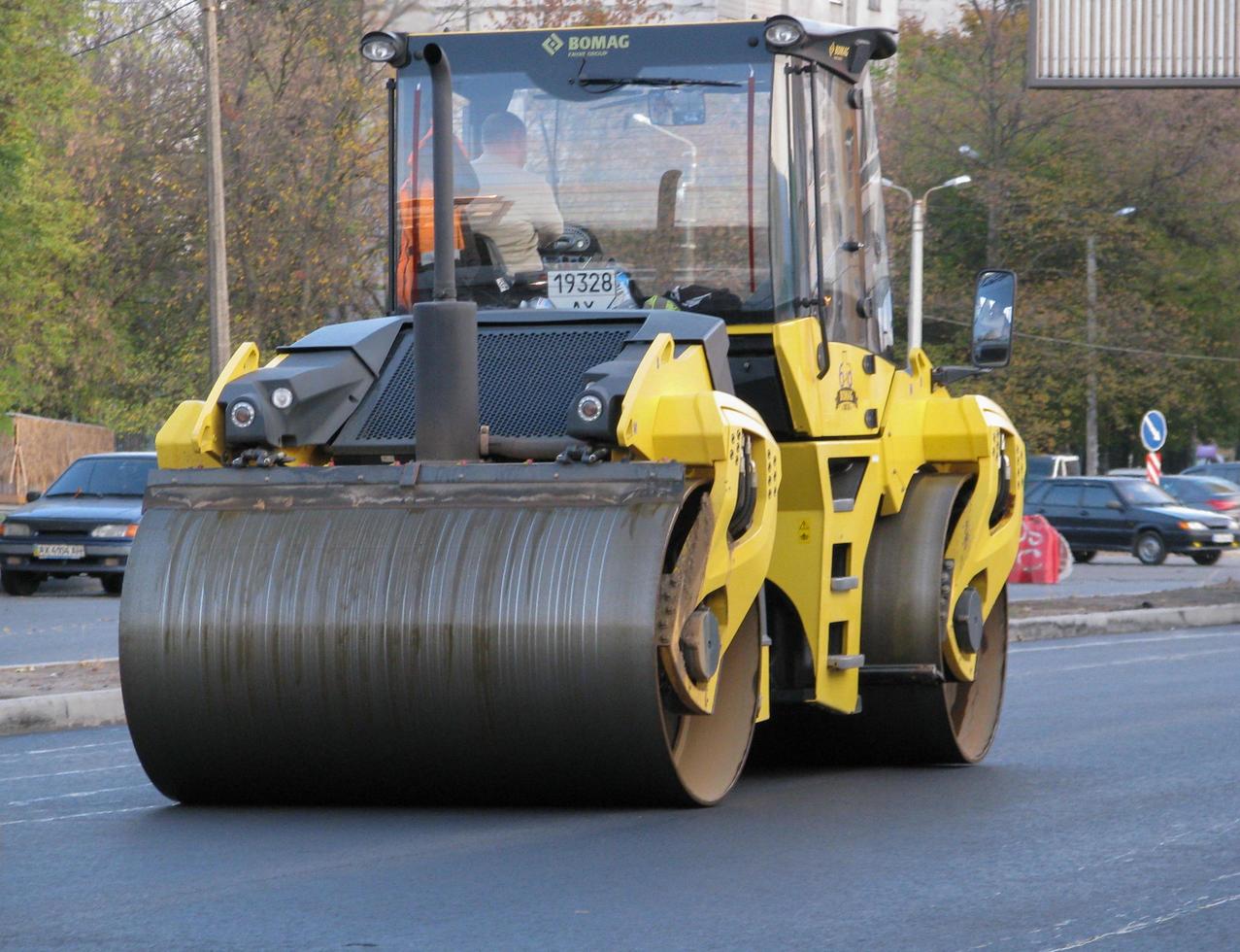 Ukraine, Kharkiv, October 27, 2020. Close-up view on the workers and the asphalting machines. Roller and workers on asphalting and repair of city streets. High quality photo