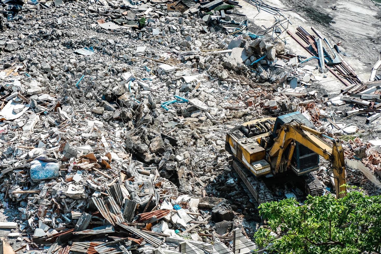 Construction working. The destroyed building is dismantled by a yellow excavator. Dismantling of the old building and start the construction of new buildings. photo