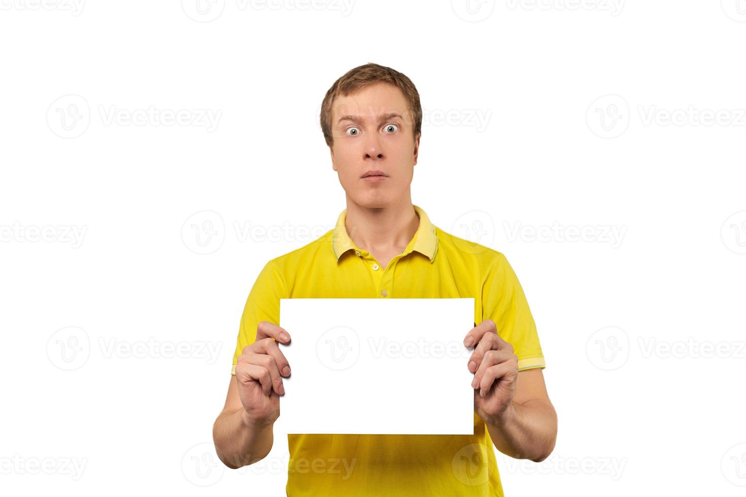 Surprised young man holding blank paper sheet, paper mockup isolated on white background photo