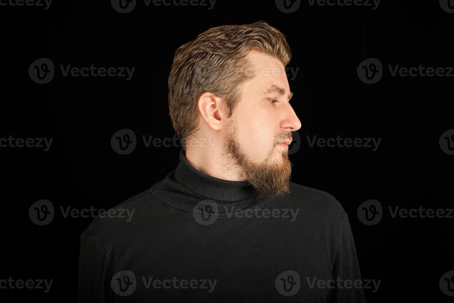 Cute bearded man, half-face portrait, black background photo