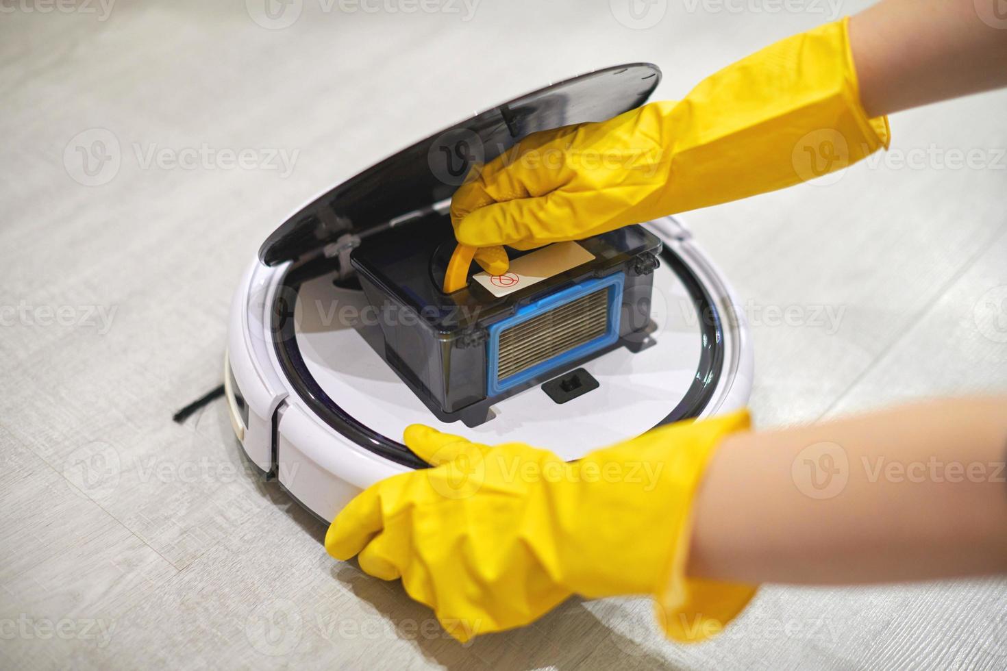 Robot vacuum cleaner, inserting filter, cleaning. Close up. photo