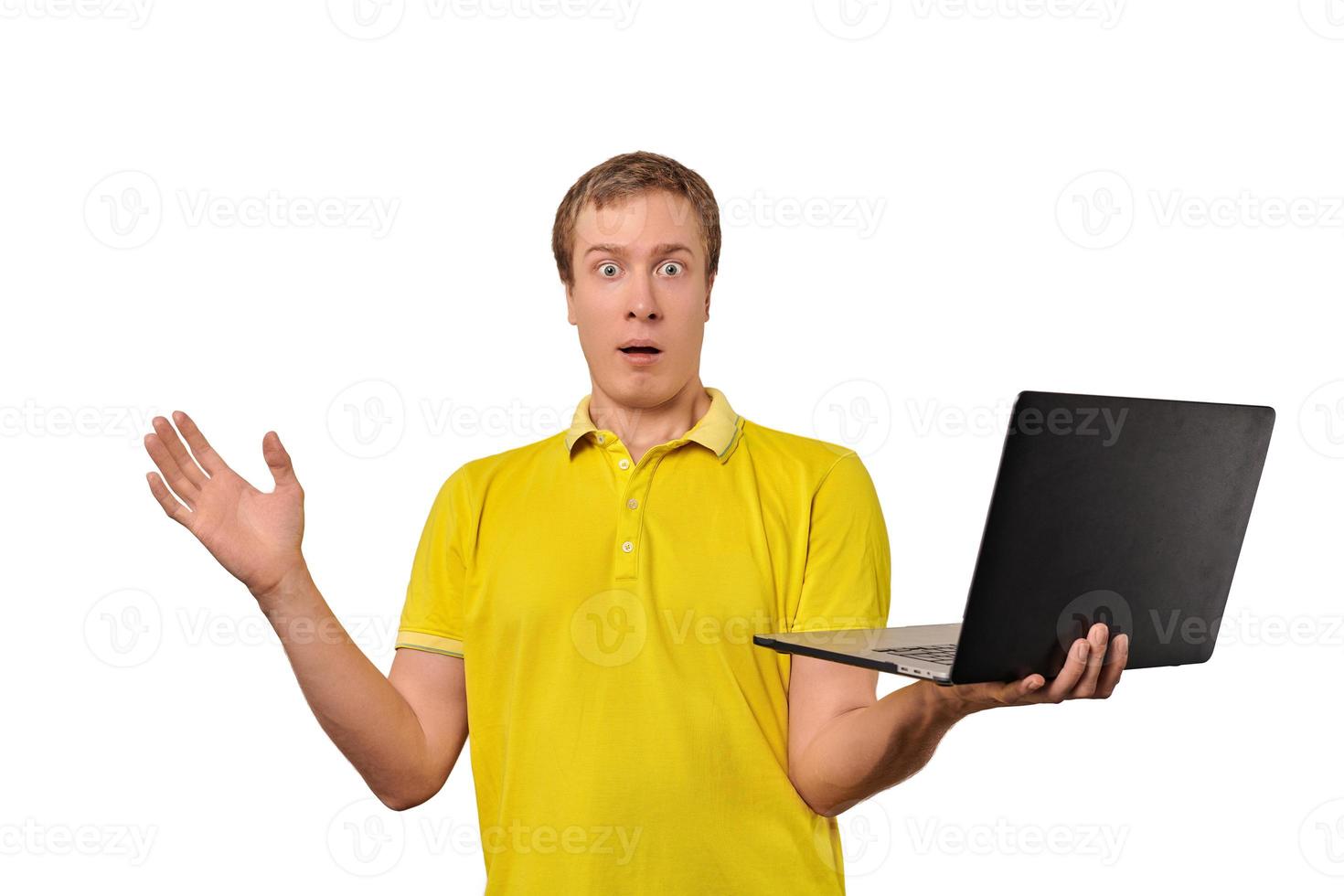 Surprised guy holding laptop in hand isolated on white background photo