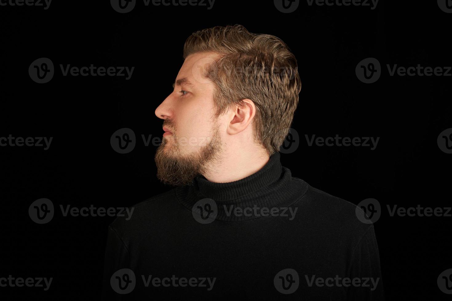 Cute bearded man, half-face portrait, black background photo