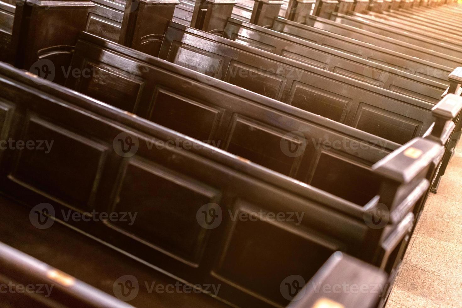 Cathedral benches. Rows of pews in christian church. Heavy solid uncomfortable wooden seats. photo