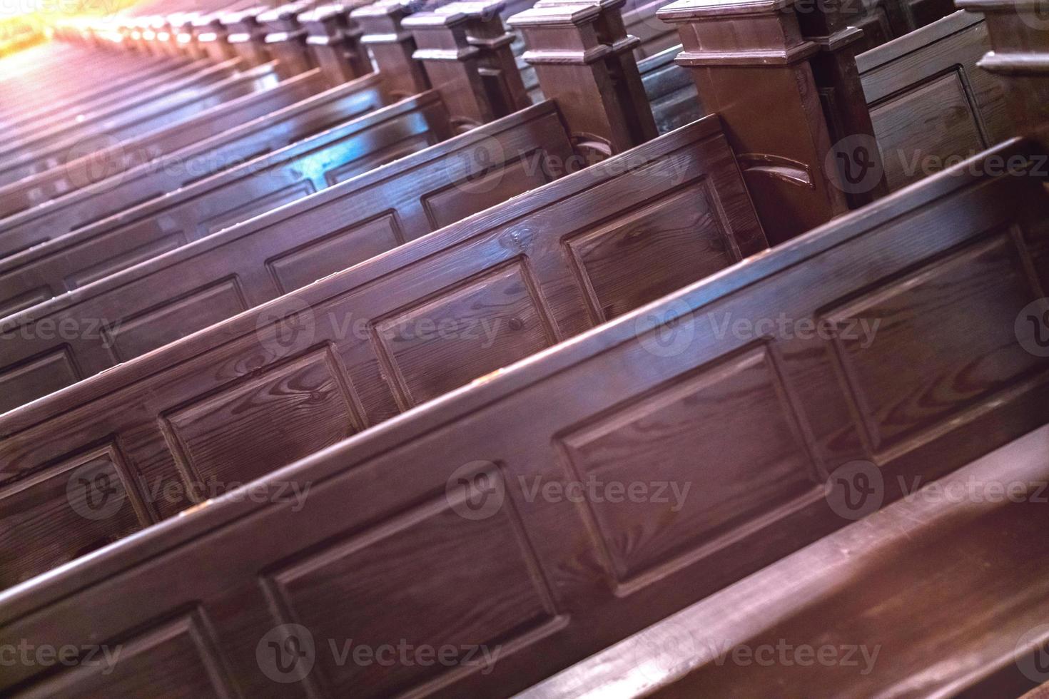 Cathedral pews. Rows of benches in christian church. Heavy solid uncomfortable wooden seats. photo