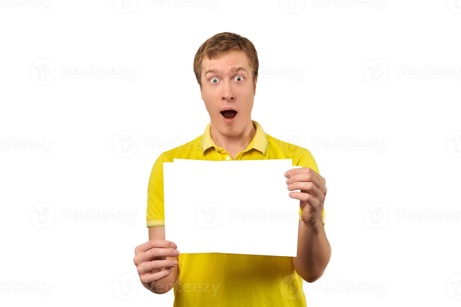 Surprised young man holding blank paper sheet, paper mockup isolated on white background photo