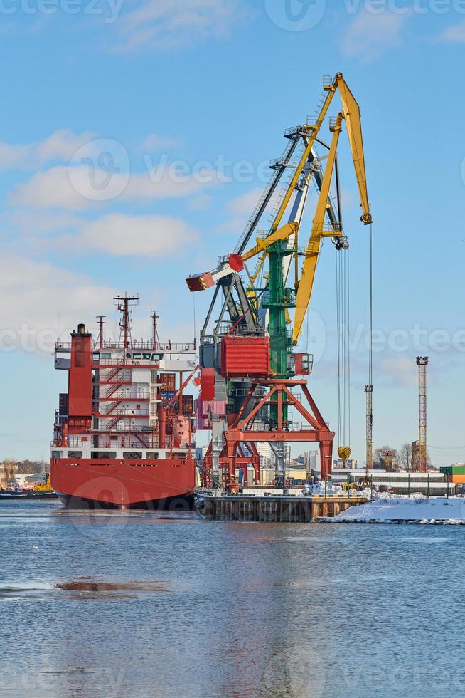 barcos amarrados y grúas portuarias en el puerto foto