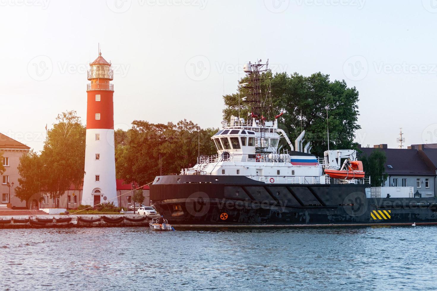 Lighthouse in seaport. Beautiful russian Baltiysk beacon. Clean blue sky. photo