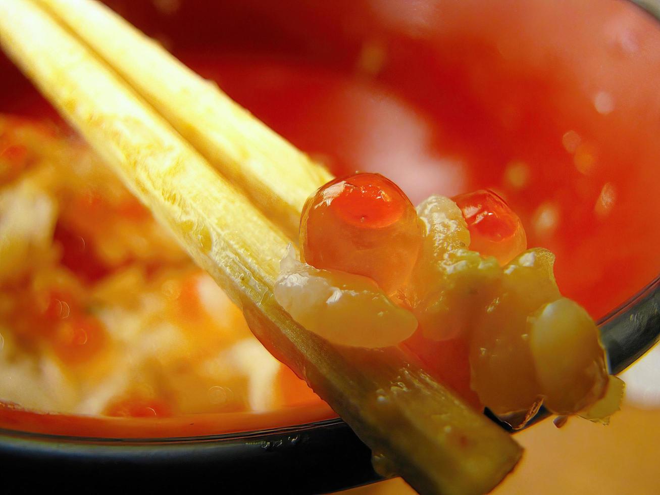 a pair of wooden chopsticks with last word salmon roe food from the empty bowl photo
