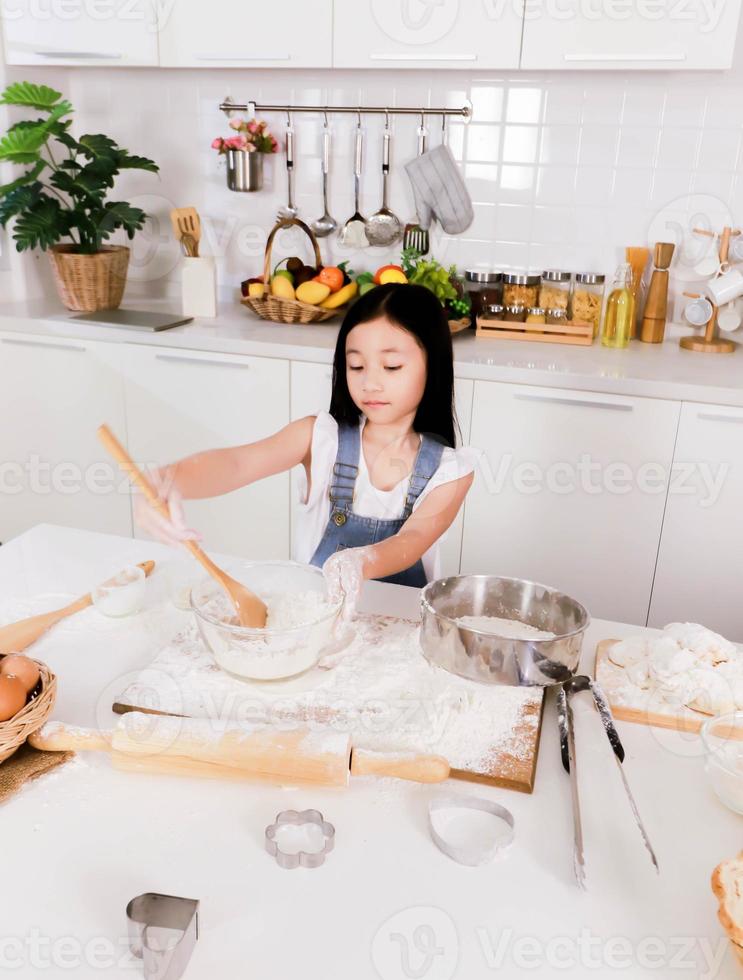 hermanita soltera hacer un horneado en la cocina foto