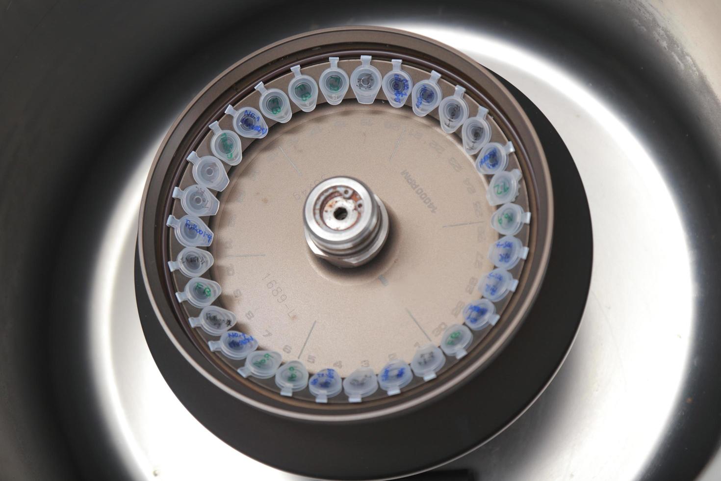 Scientist loading a sample to centrifuge photo