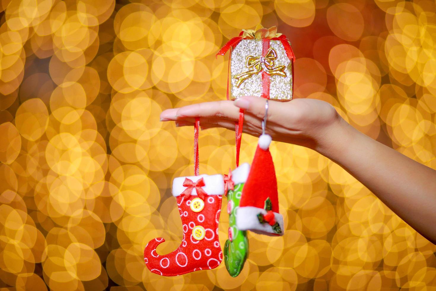 Merry Christmas and Happy New Year. Gift Christmas in woman's hands with glowing hearts bokeh. photo