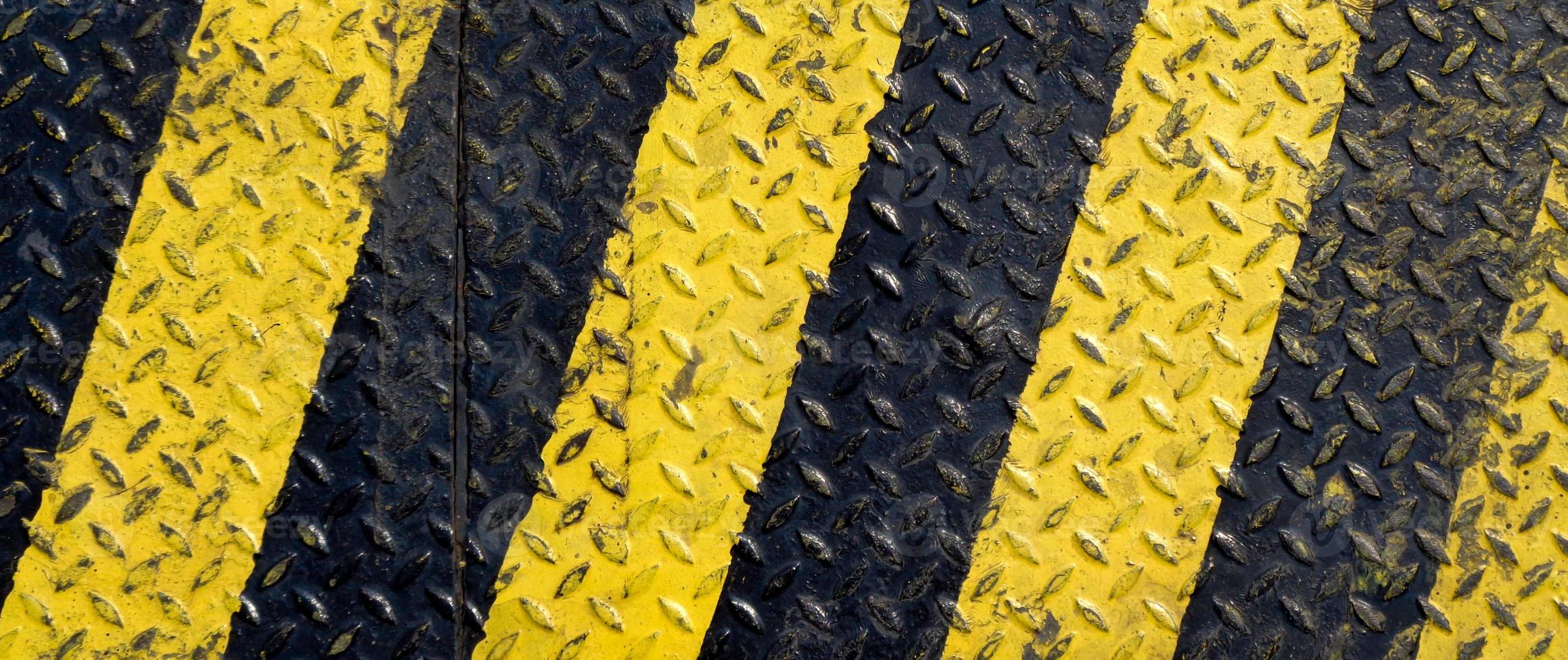 Black and yellow line paint on non-slip metal background photo